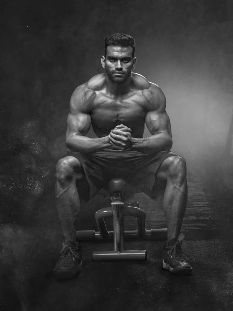 Grayscale Photo of Man Sitting on Bench